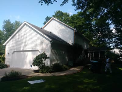 House exterior with pale siding and dark roof line.