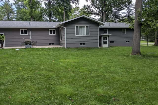 The same ranch house finished in charcoal grey with white trim.